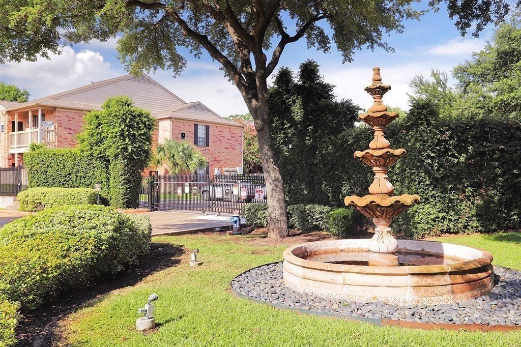 a view of a house with fountain in front of house