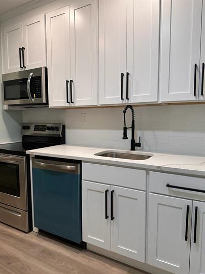 a kitchen with white cabinets and white appliances