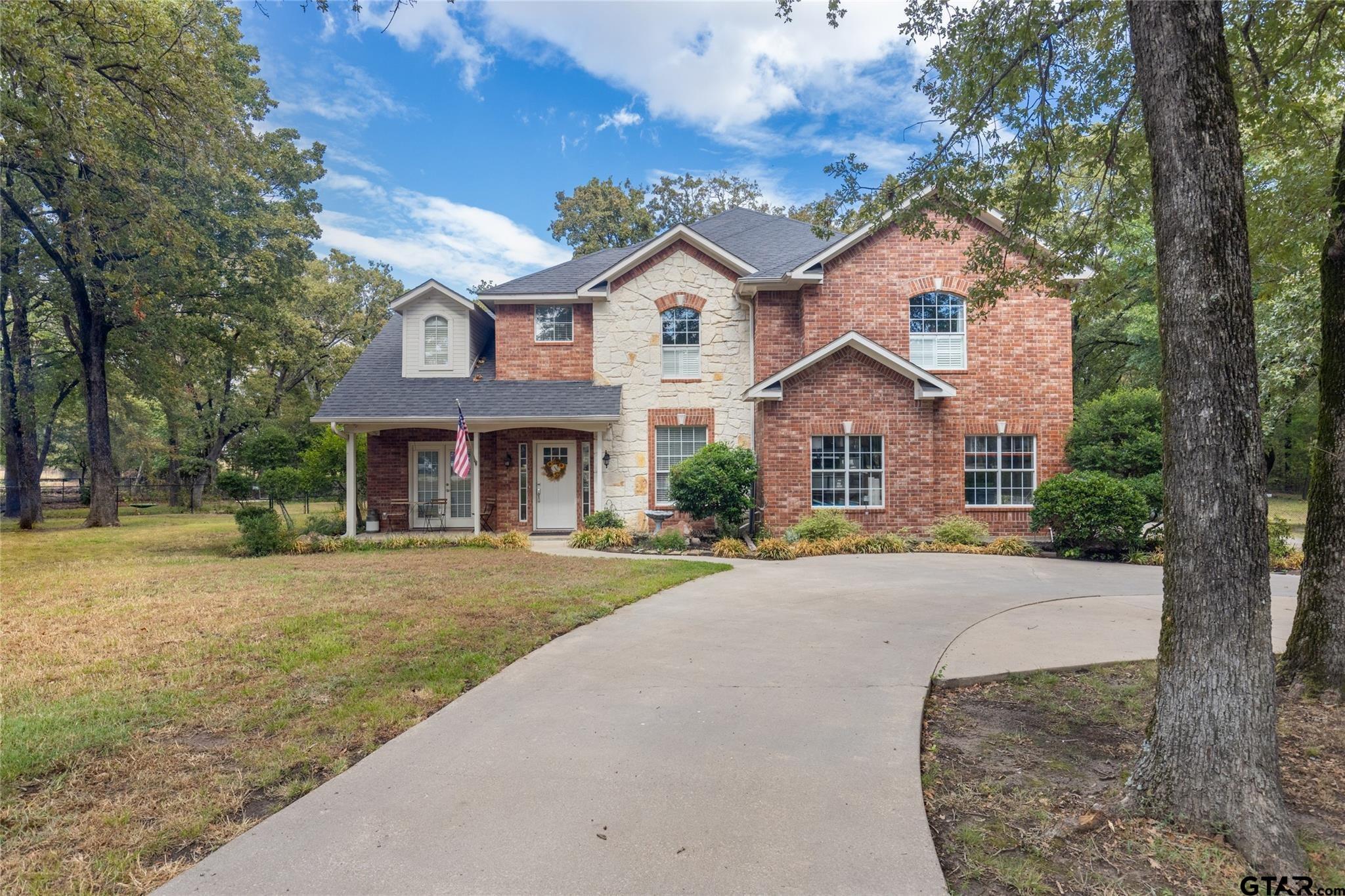 a front view of a house with yard and parking