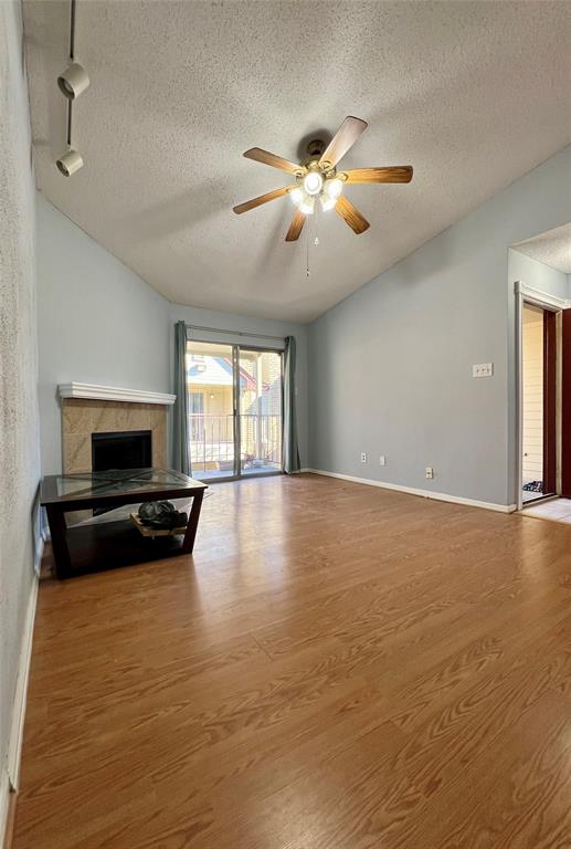 a view of a livingroom with a flat screen tv ceiling fan and hardwood floor