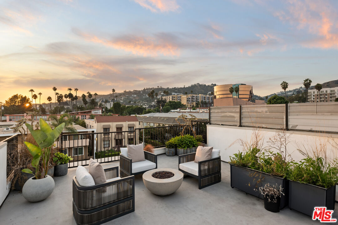 a view of a patio with couches potted plants and water view