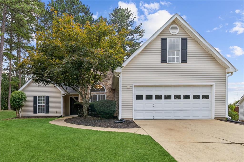 a view of house with yard and garage