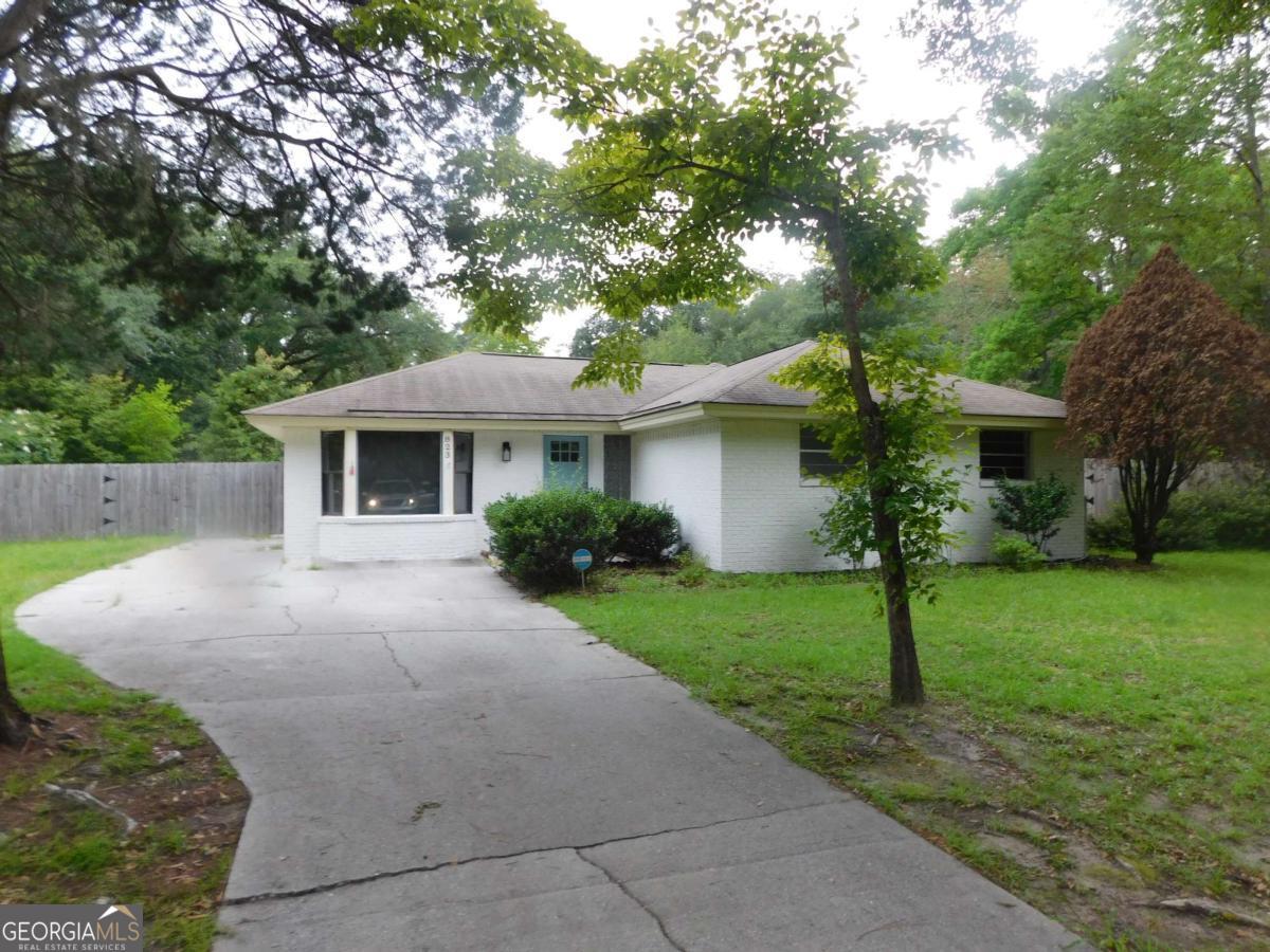 a front view of a house with a yard and trees