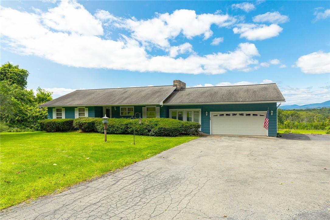 Single story home with a garage and a front yard