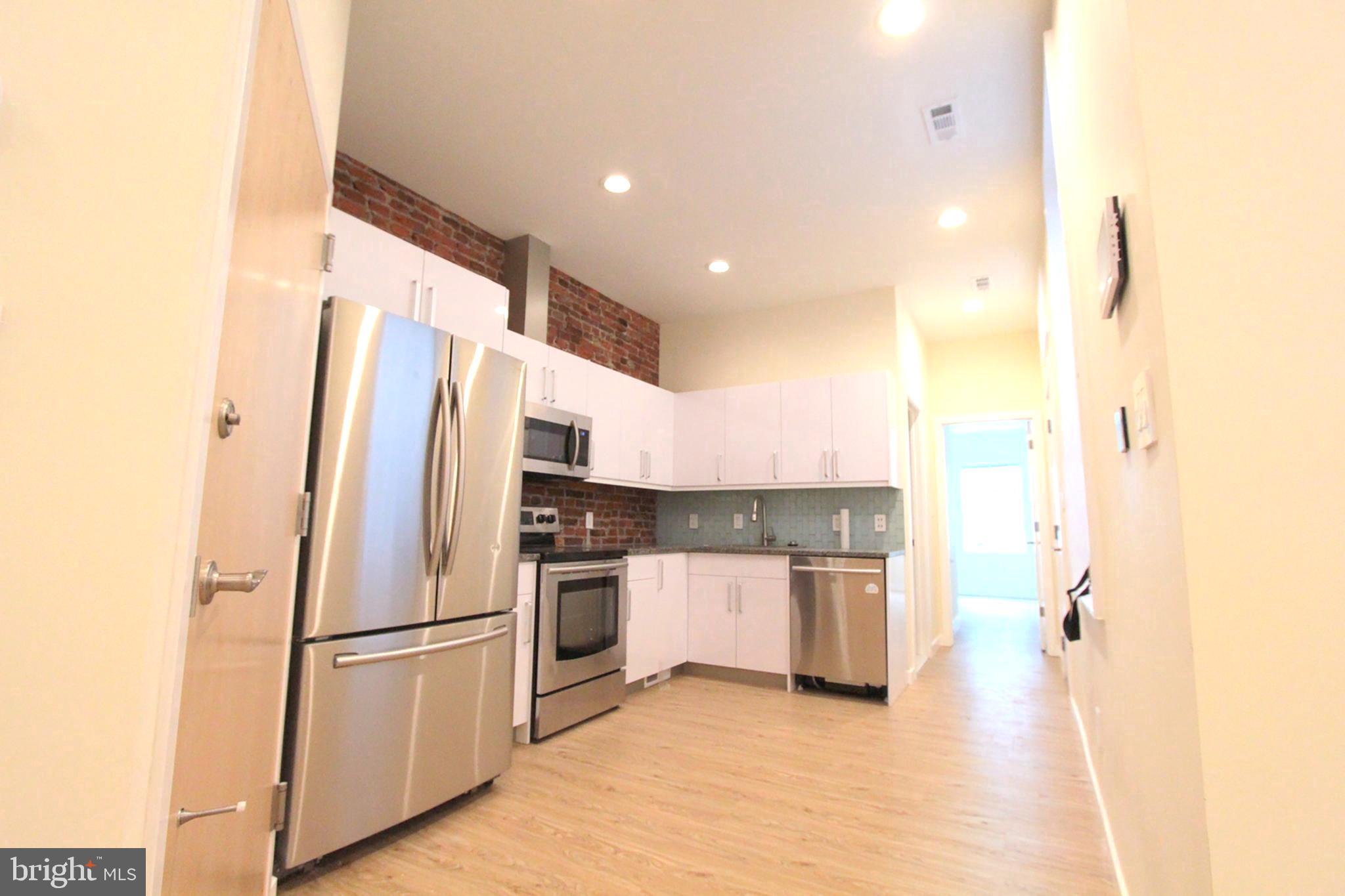 a kitchen with stainless steel appliances a refrigerator sink and microwave