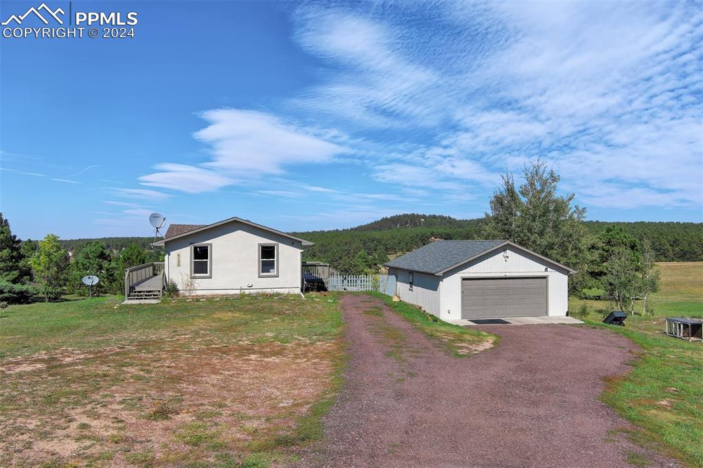 View of front of property featuring a garage and an outdoor structure