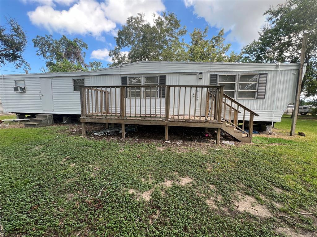 a view of a house with a wooden deck and a yard