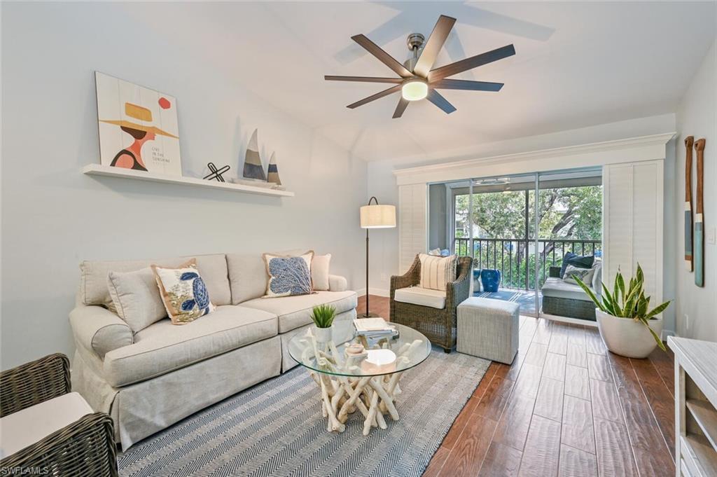 Living room with ceiling fan and dark hardwood / wood-style floors