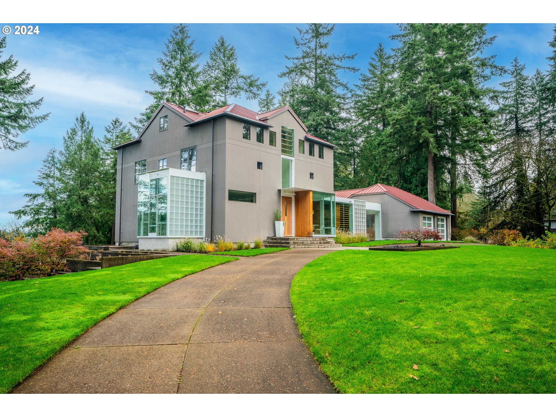 a front view of a house with a yard and trees