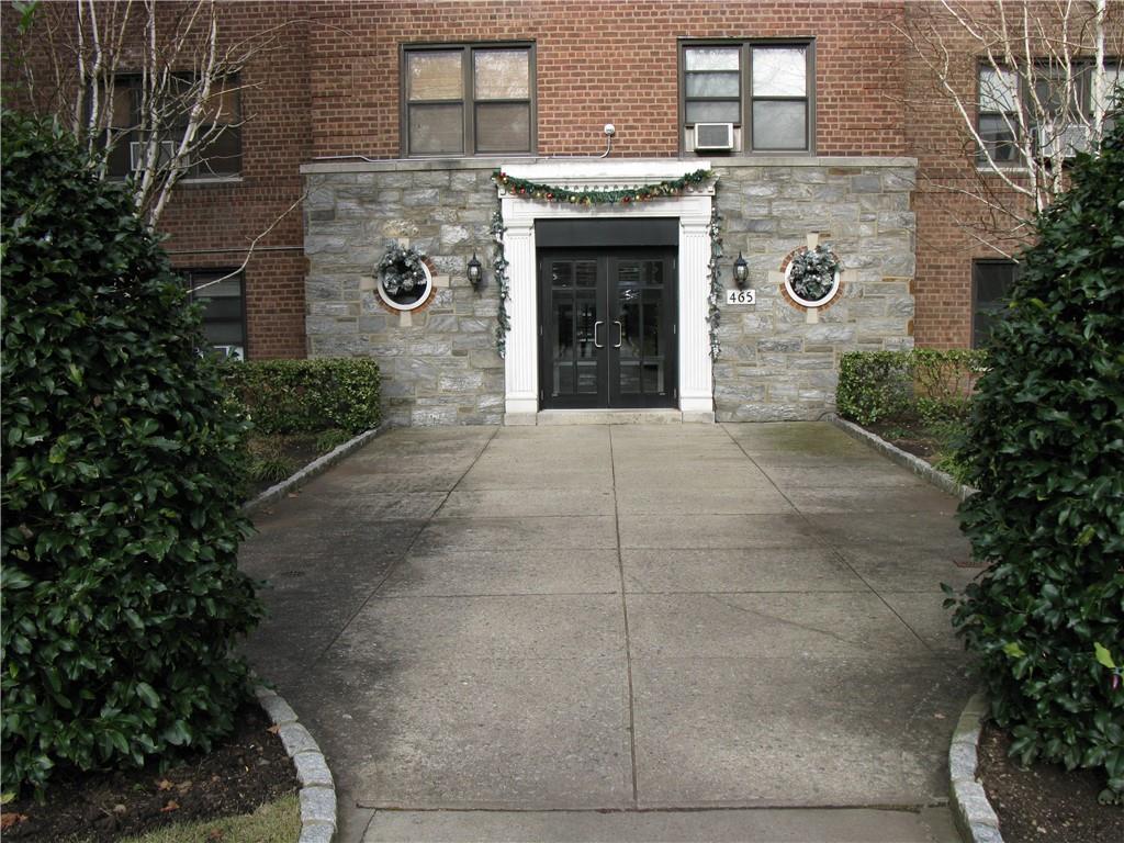 a stone house with plants in front of it