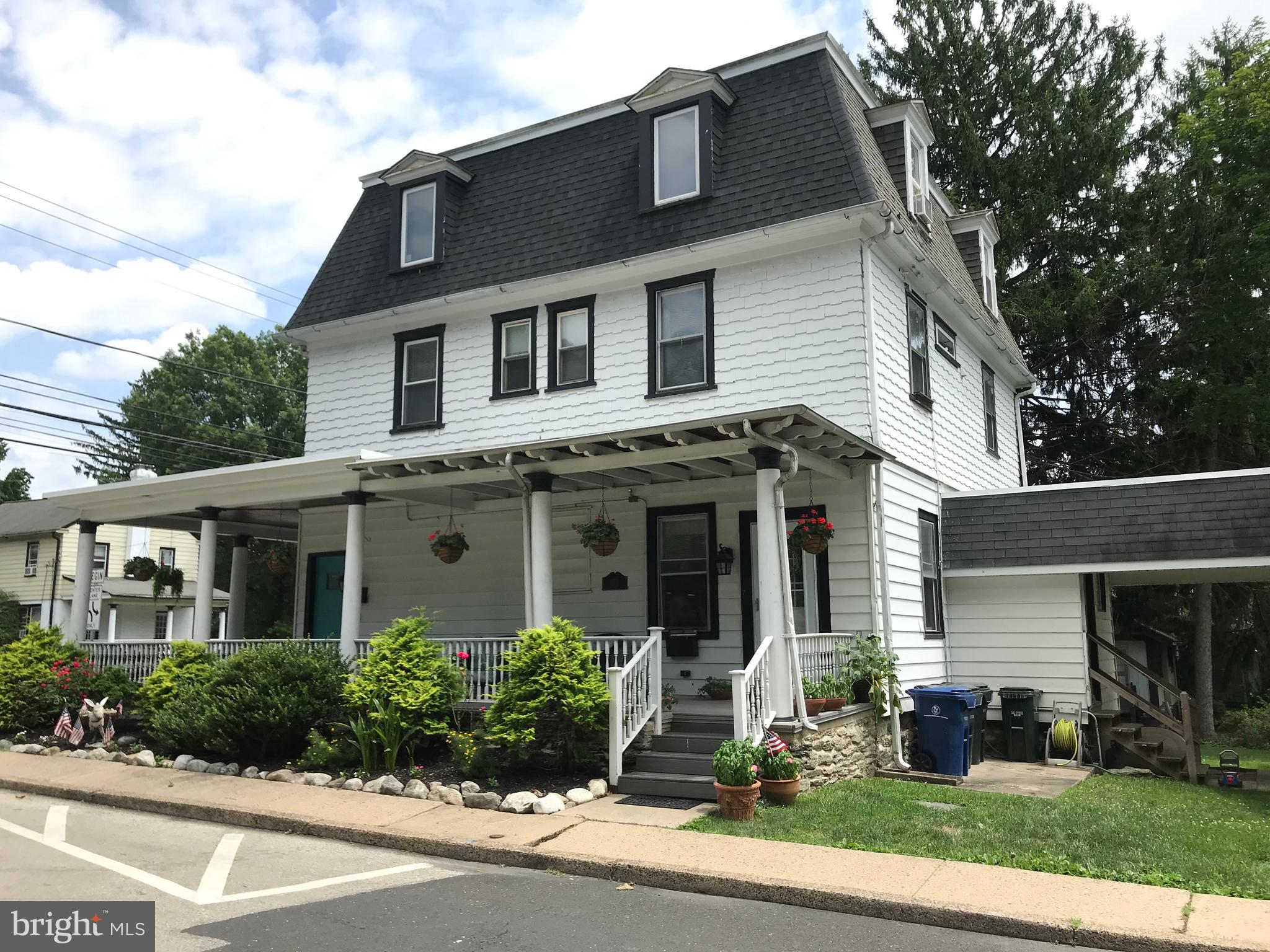 a front view of a house with trees and plants