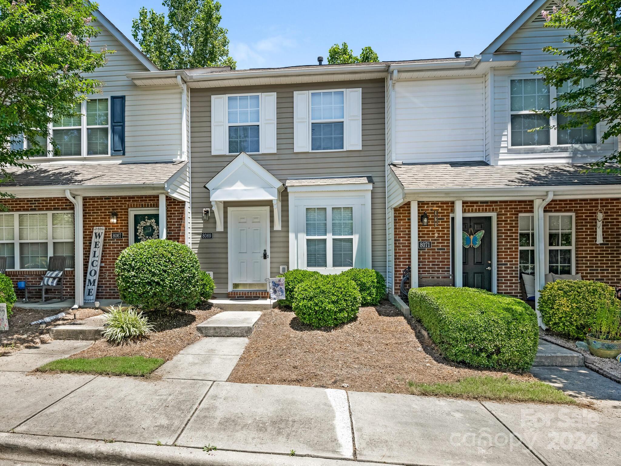 front view of a brick house with a yard