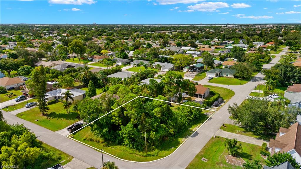 an aerial view of residential houses with outdoor space and trees