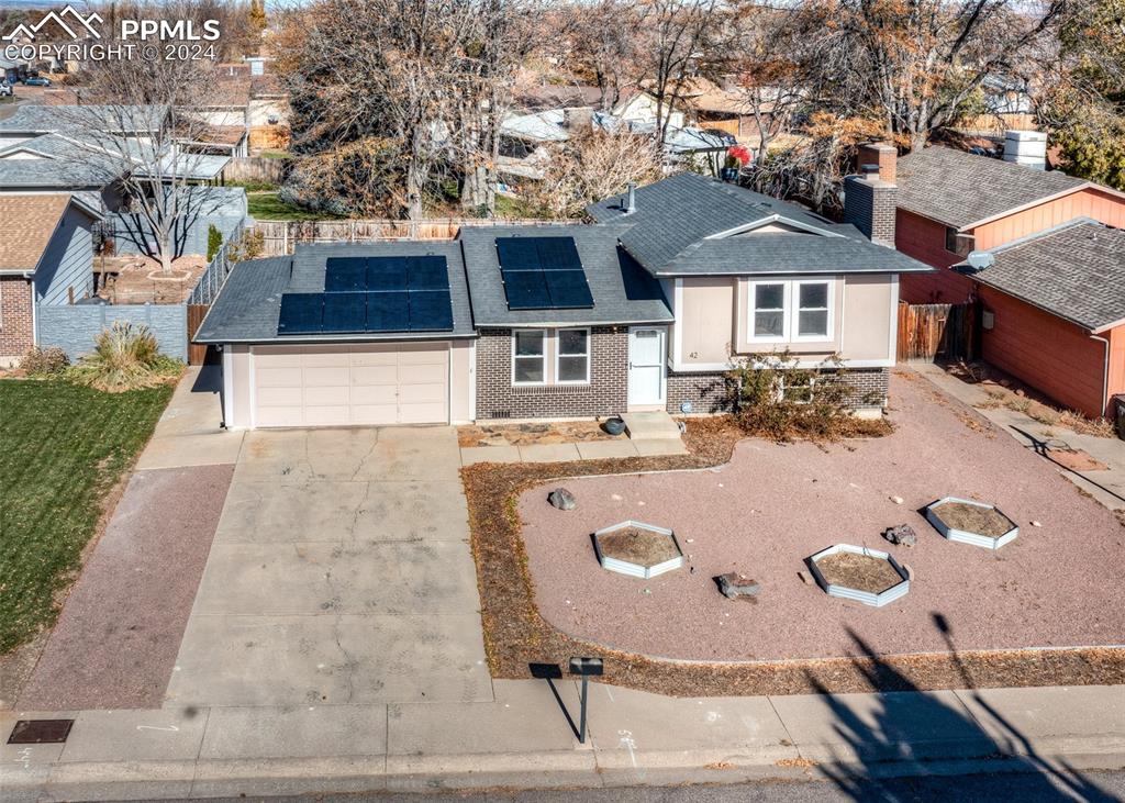 View of front of house featuring solar panels and a garage