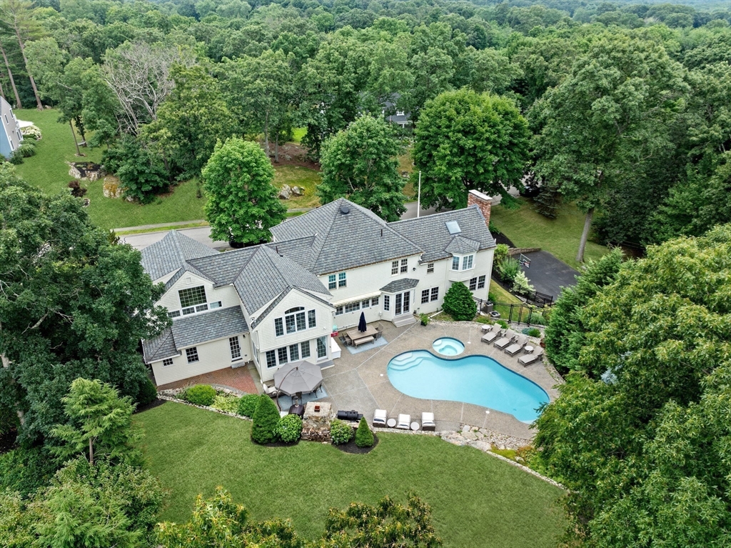 an aerial view of residential houses with outdoor space and trees