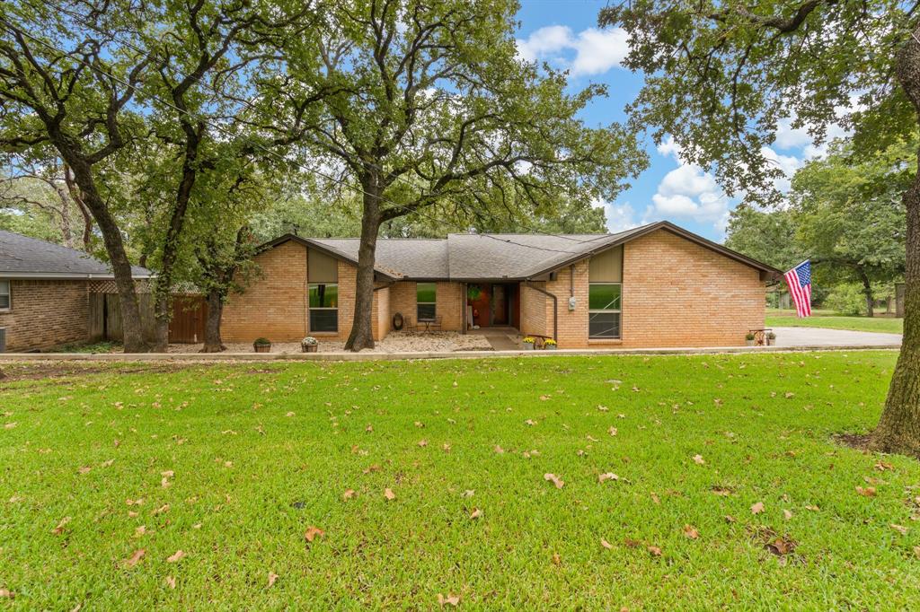 a view of a house with backyard and a tree