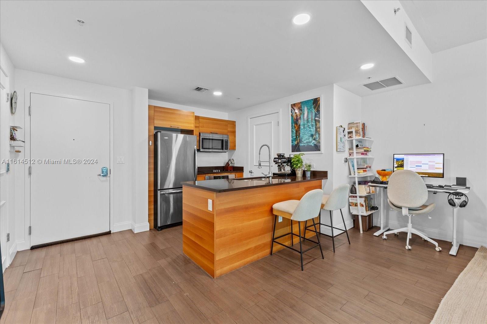 a living room with furniture a refrigerator and wooden floor