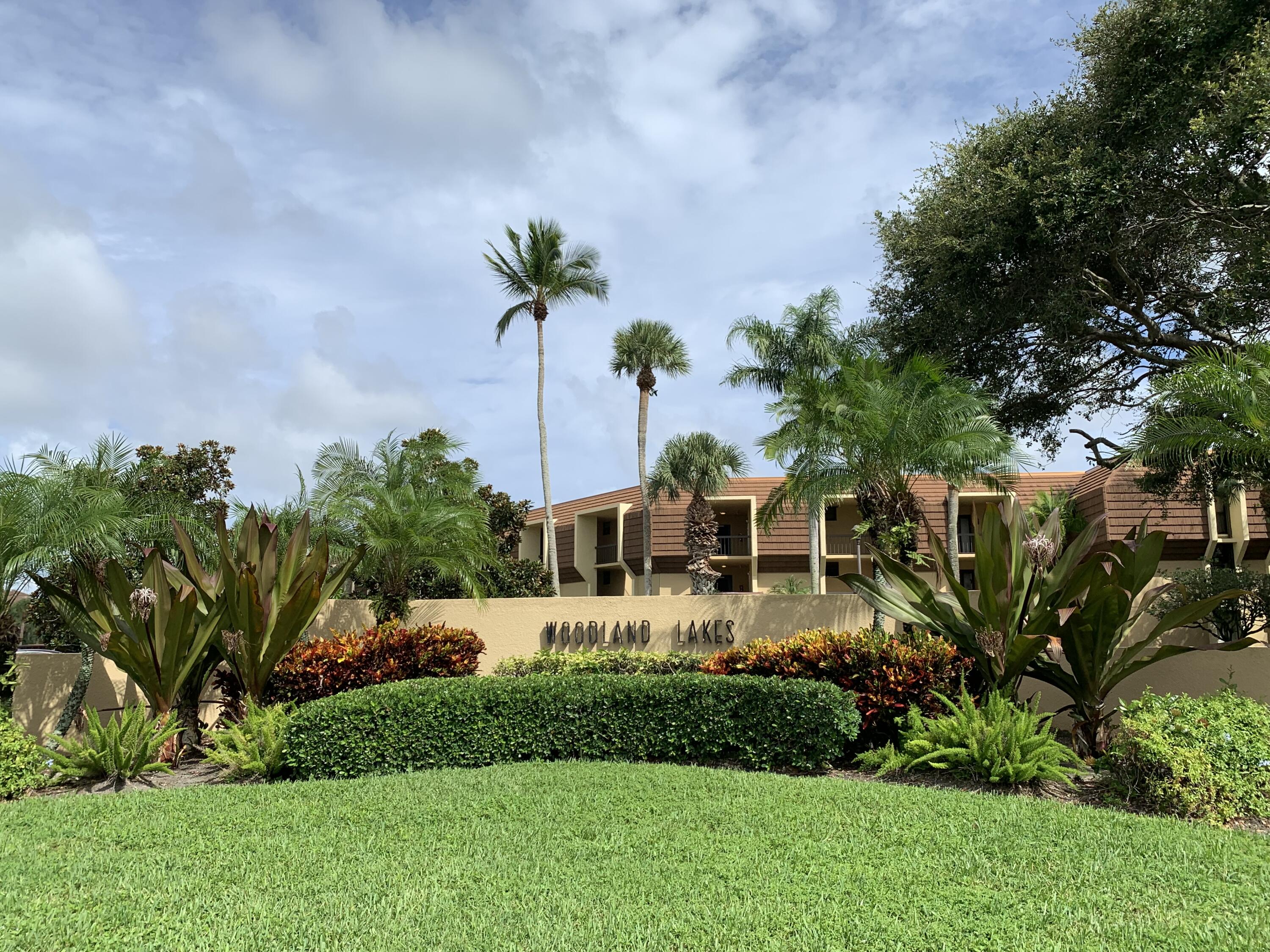 a front view of a house with a garden and trees