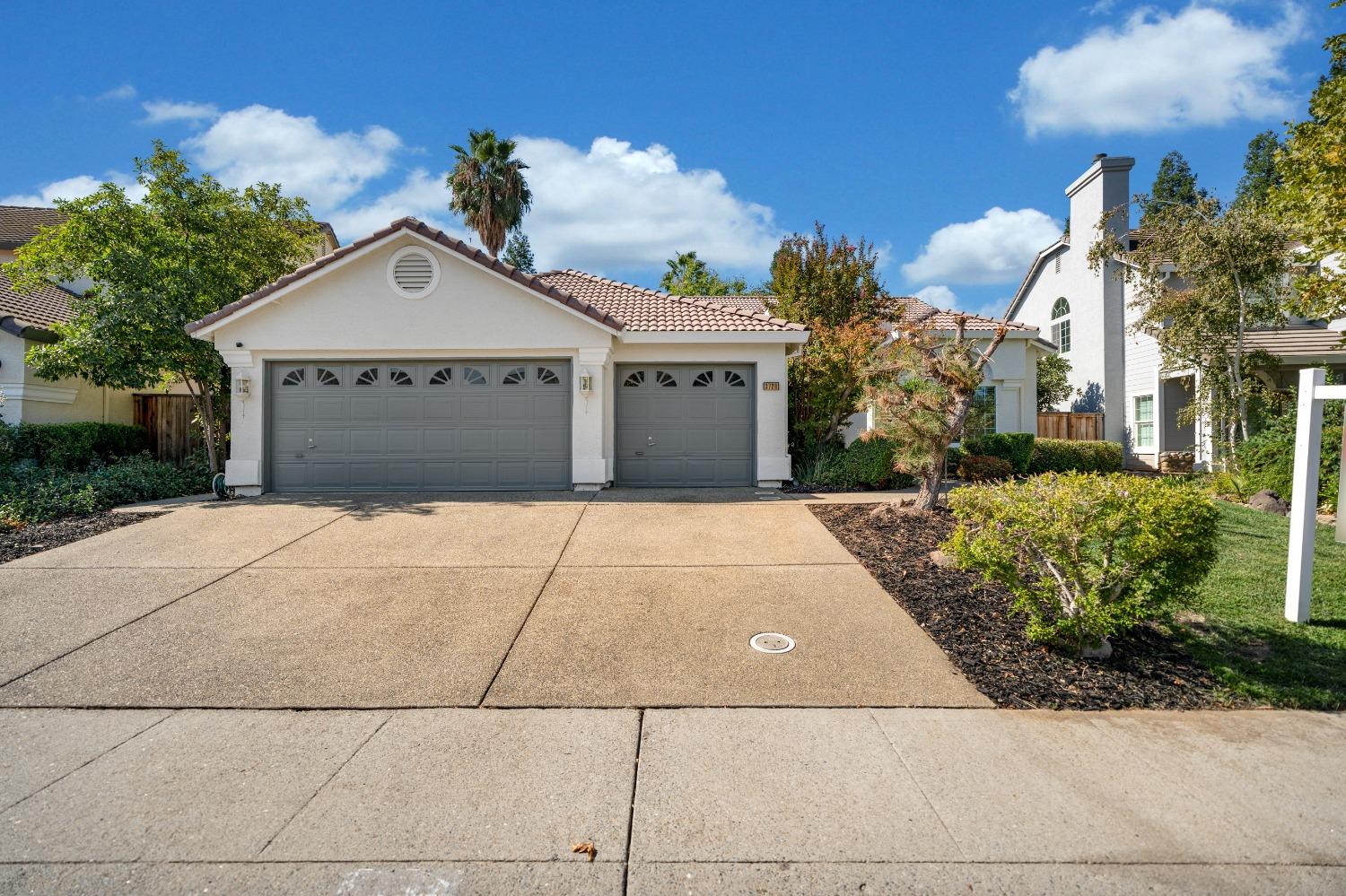 a front view of a house with a yard and potted plants