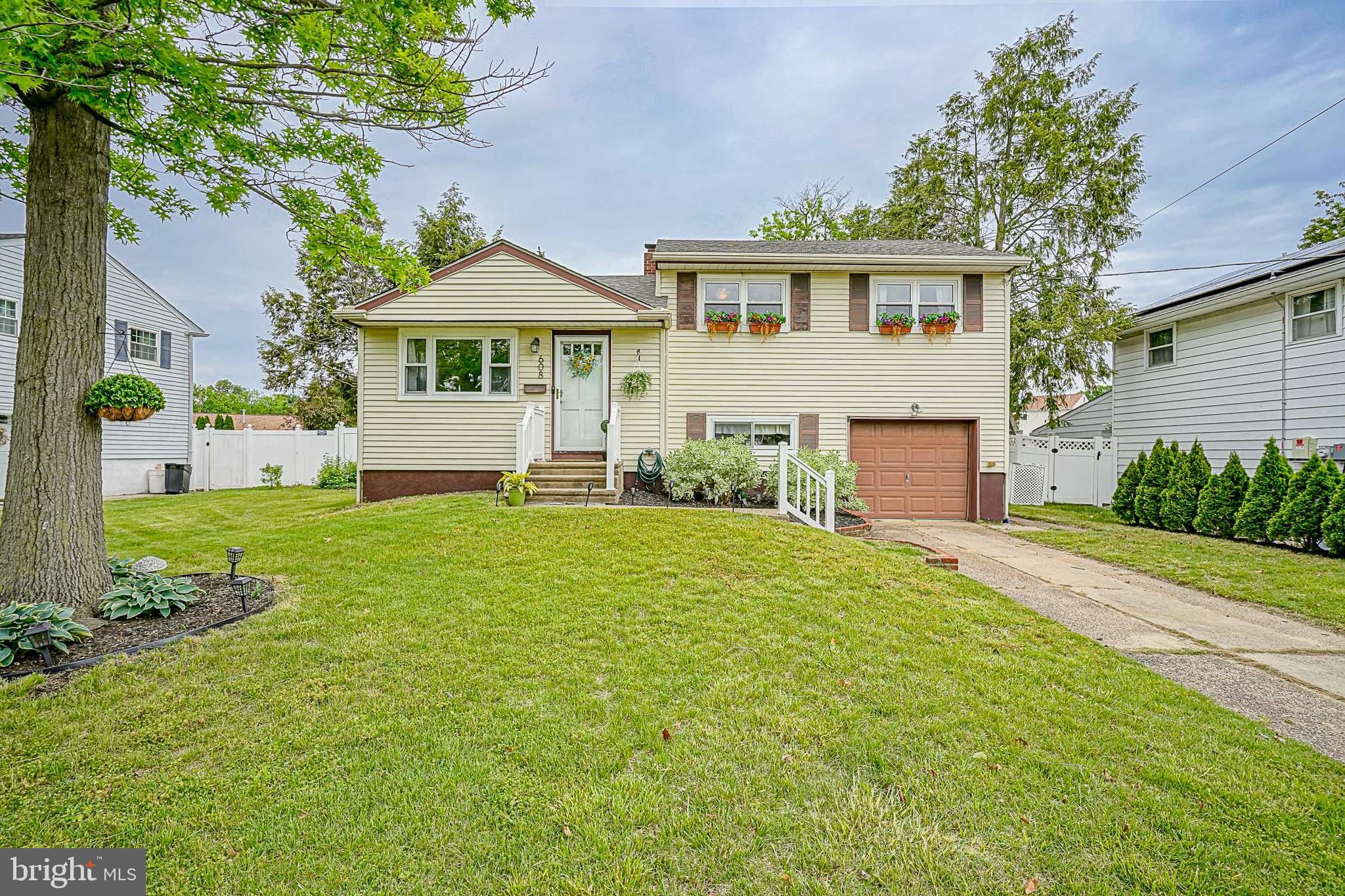 a front view of a house with a yard and trees