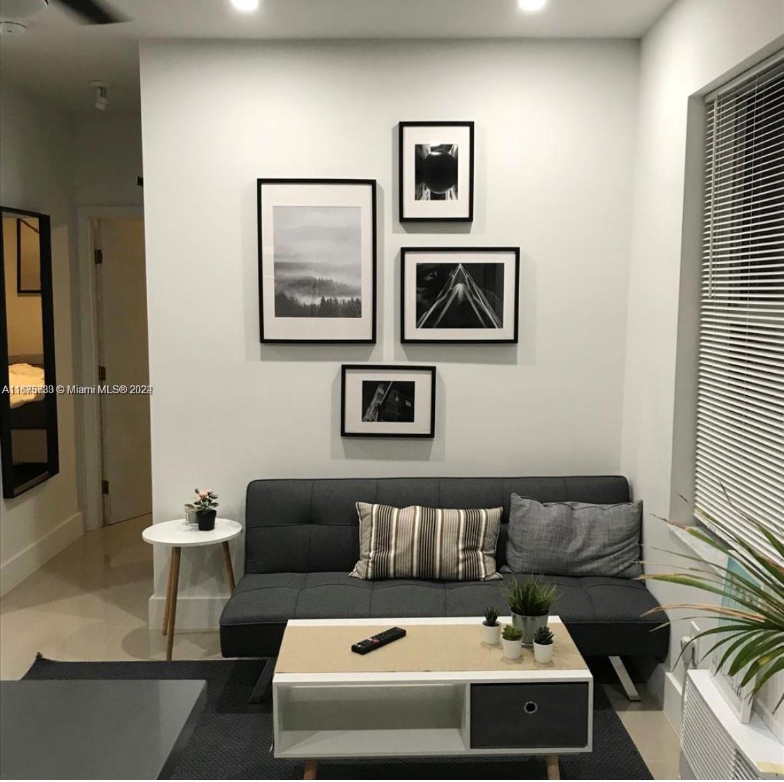 a living room with furniture and painting on the wall