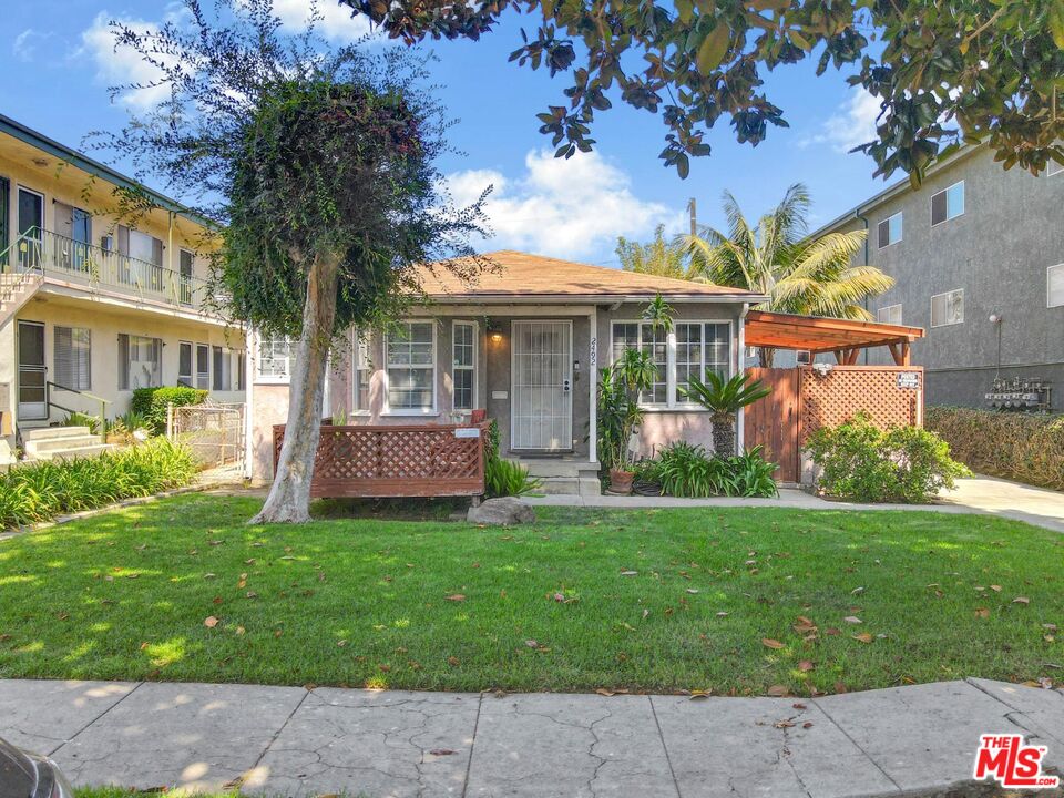 a front view of a house with a garden and trees