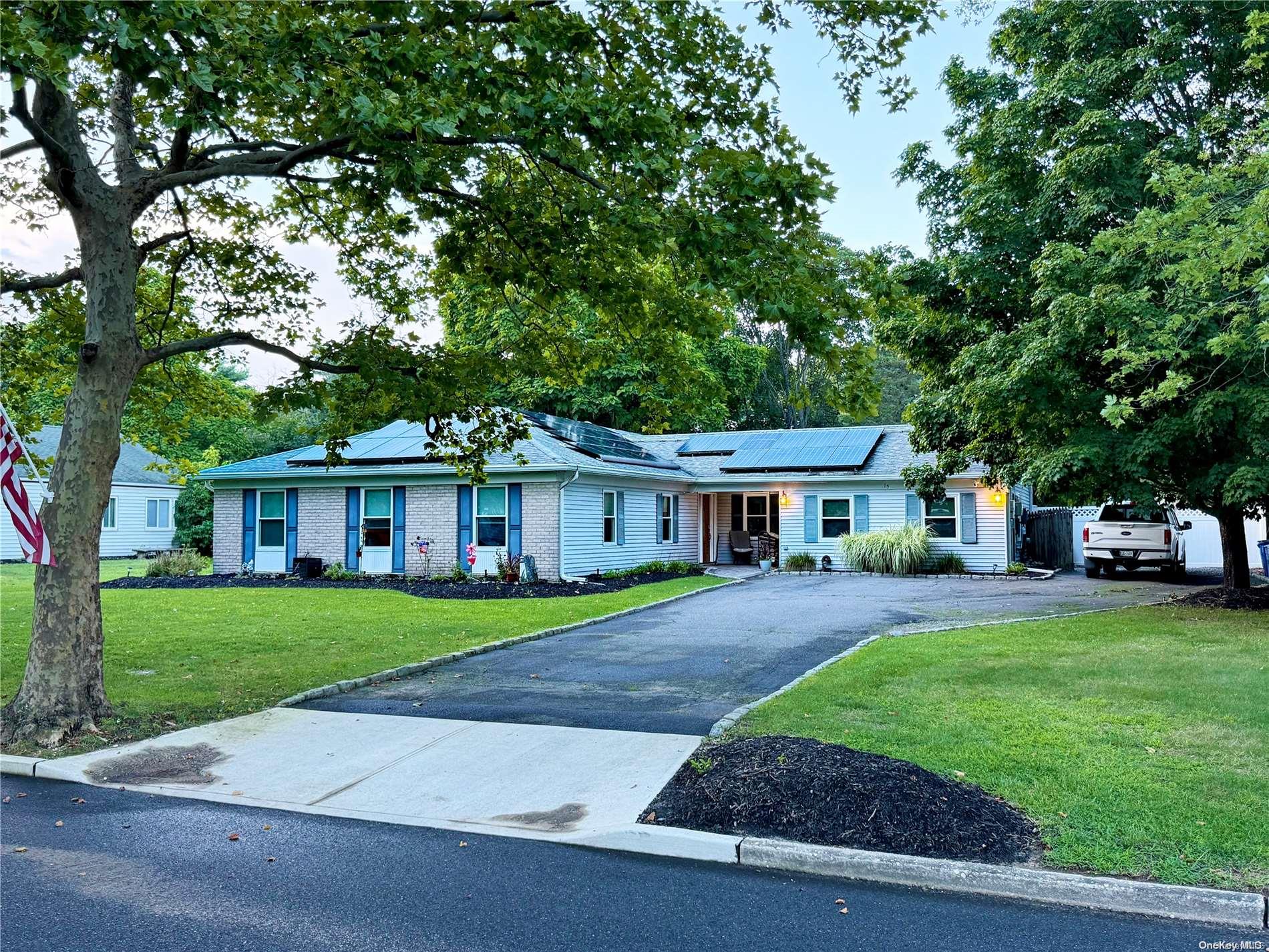 front view of a house and a yard and trees