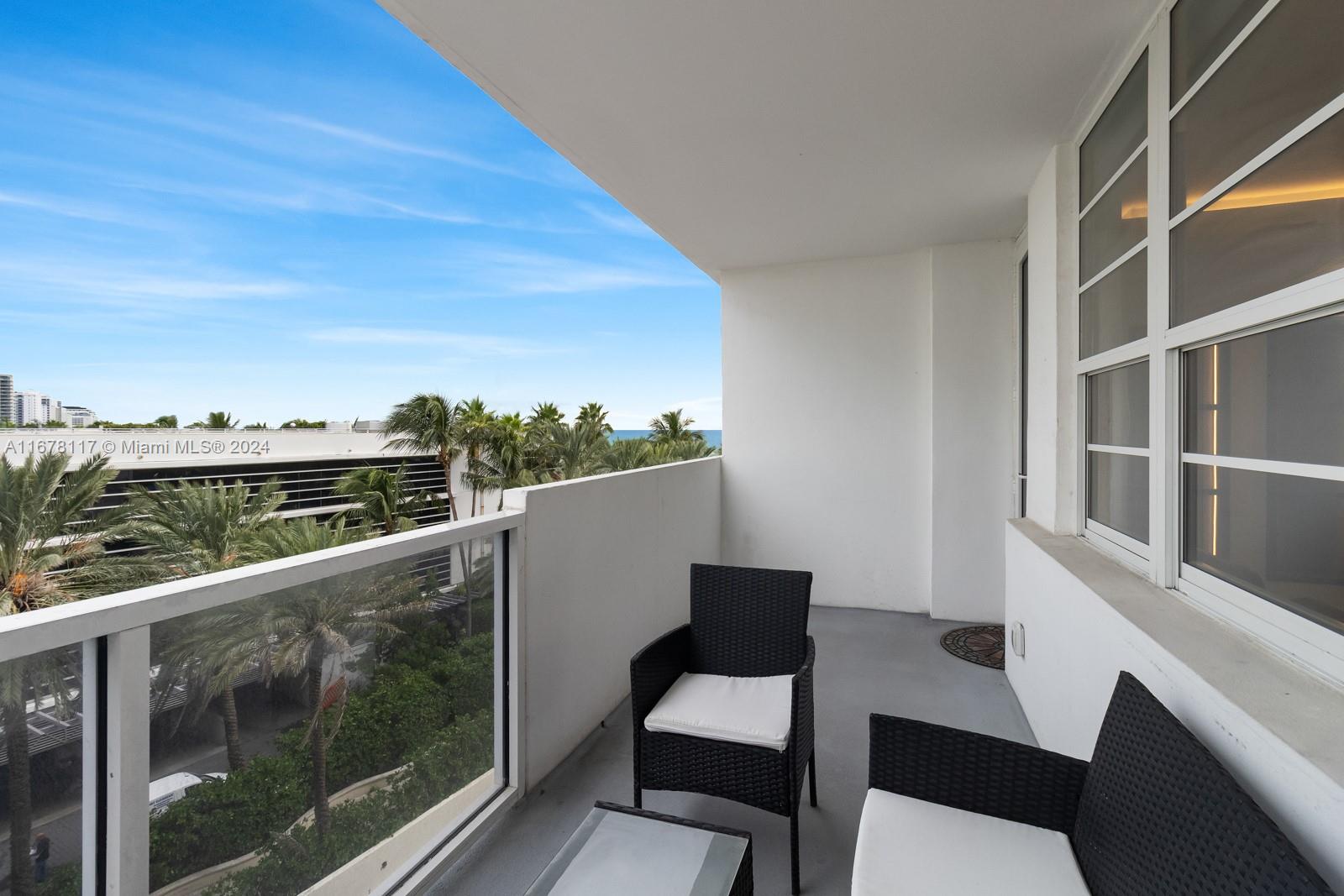 a view of a balcony with chair and wooden floor