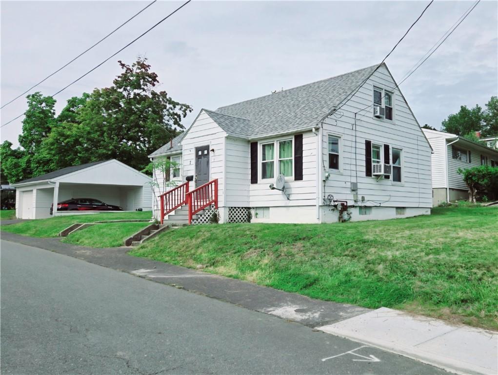 View of front facade featuring a front yard and a carport