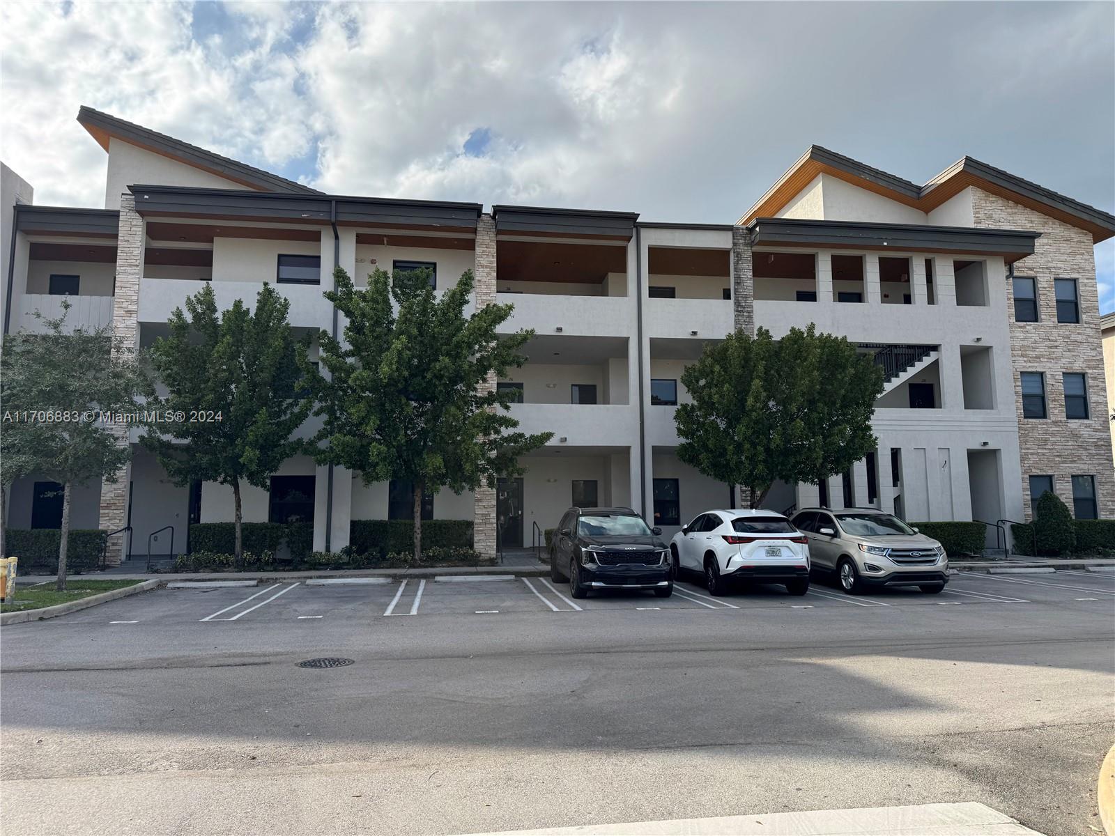 a view of a building with a cars park in front of it