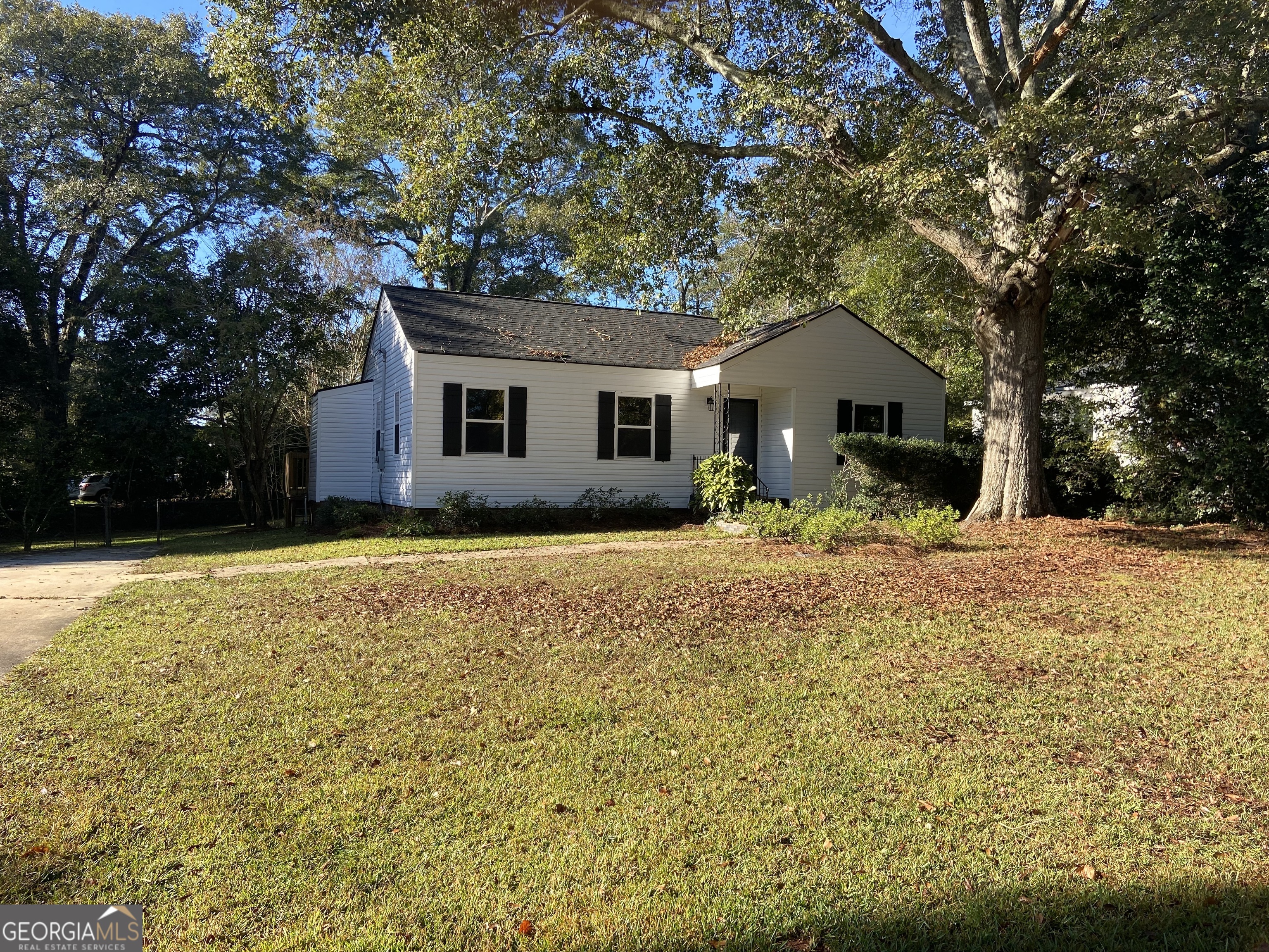 a front view of house with yard and trees around