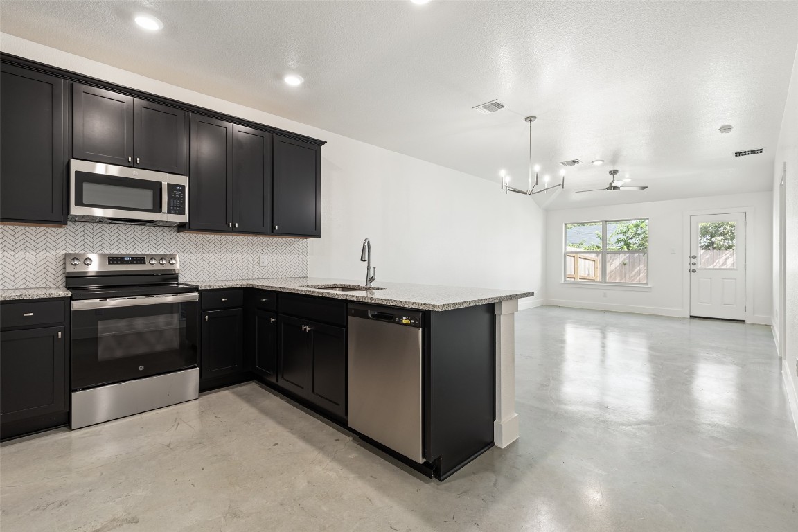 a kitchen with a sink and steel appliances