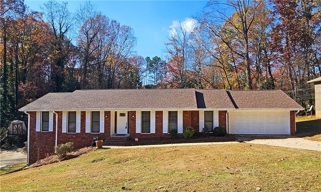 a front view of a house with yard and trees