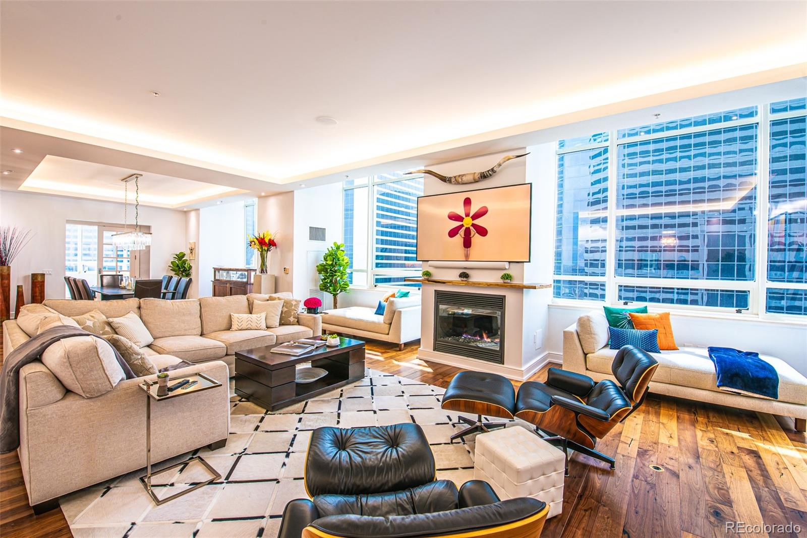 a living room with furniture fireplace and a large window