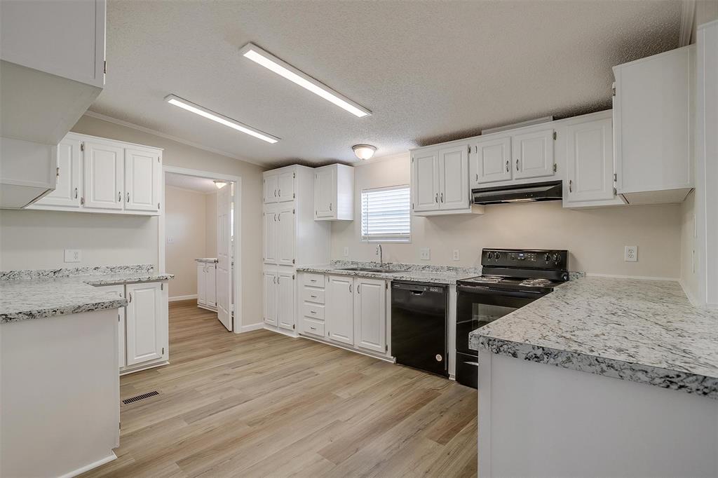 a kitchen with granite countertop a stove sink and cabinets