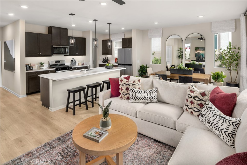 a living room with stainless steel appliances kitchen island granite countertop a couch and a view of kitchen