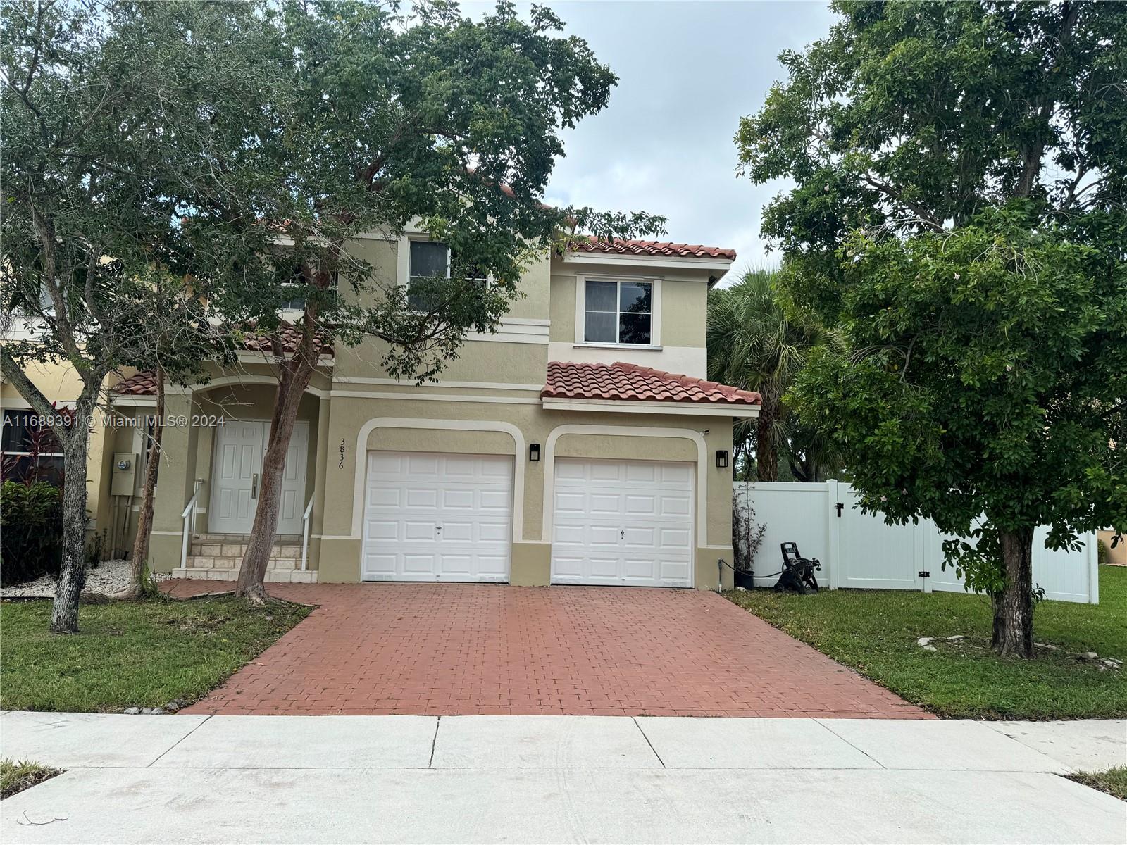 a front view of a house with a yard and trees