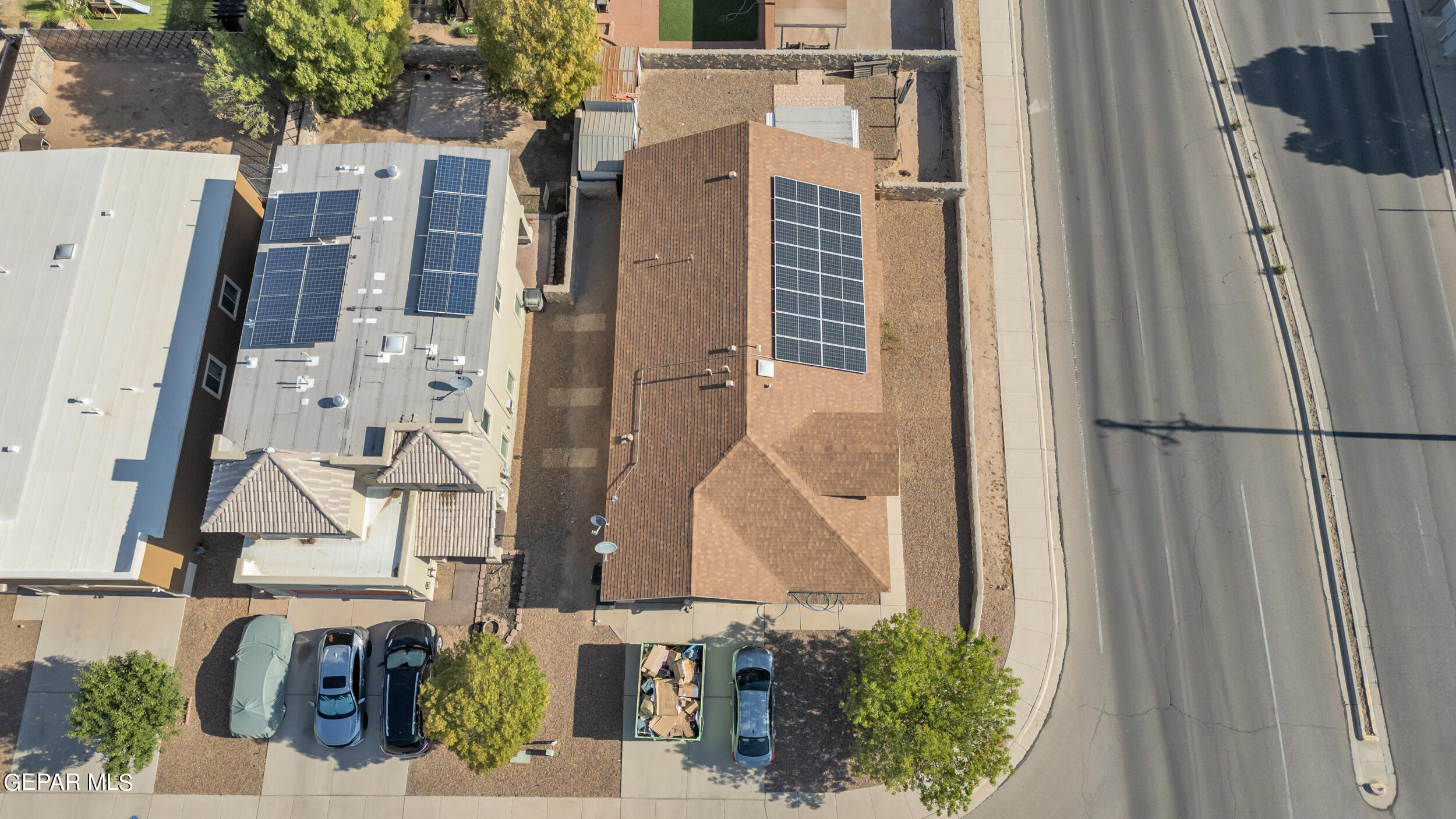 an aerial view of residential houses with outdoor space and parking