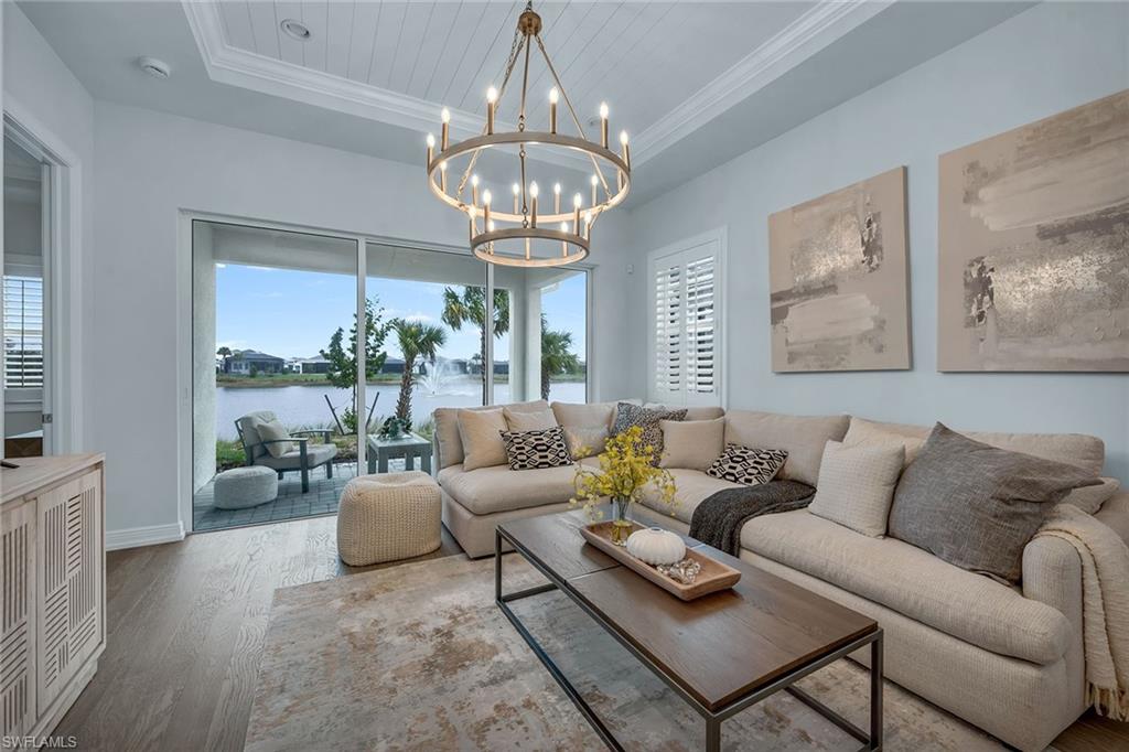 a living room with furniture chandelier and a large window