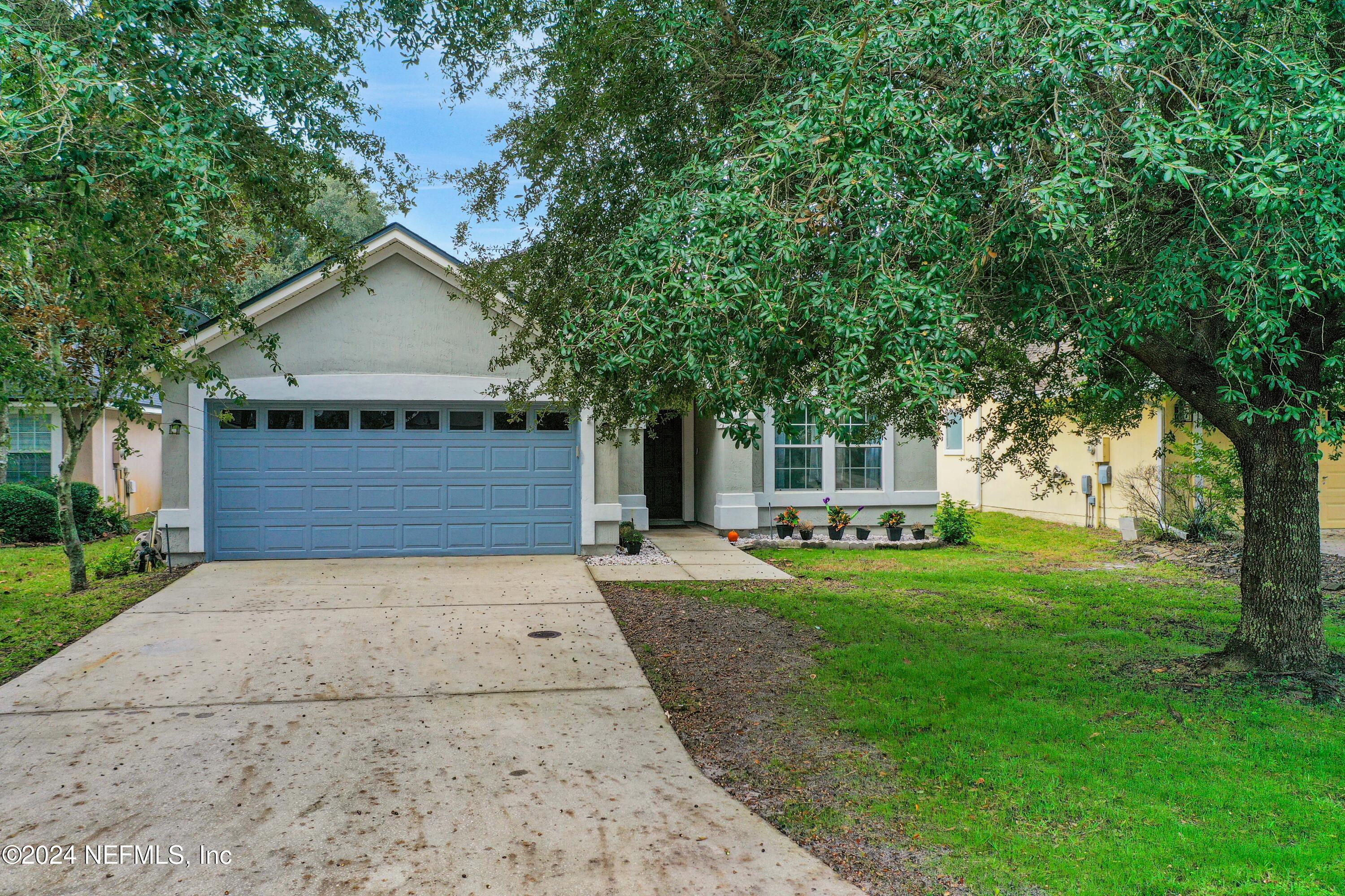 a front view of a house with a yard and trees