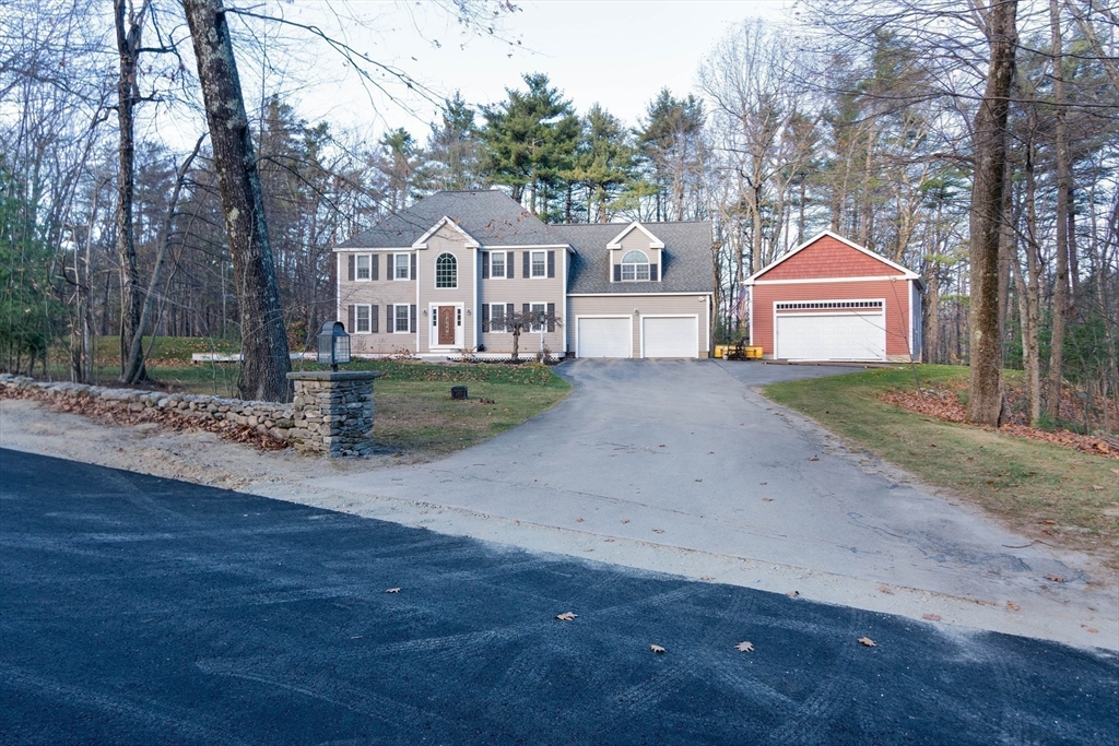 a front view of a house with a garden and trees