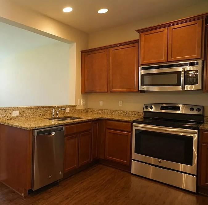 a kitchen with stainless steel appliances a stove a microwave and sink