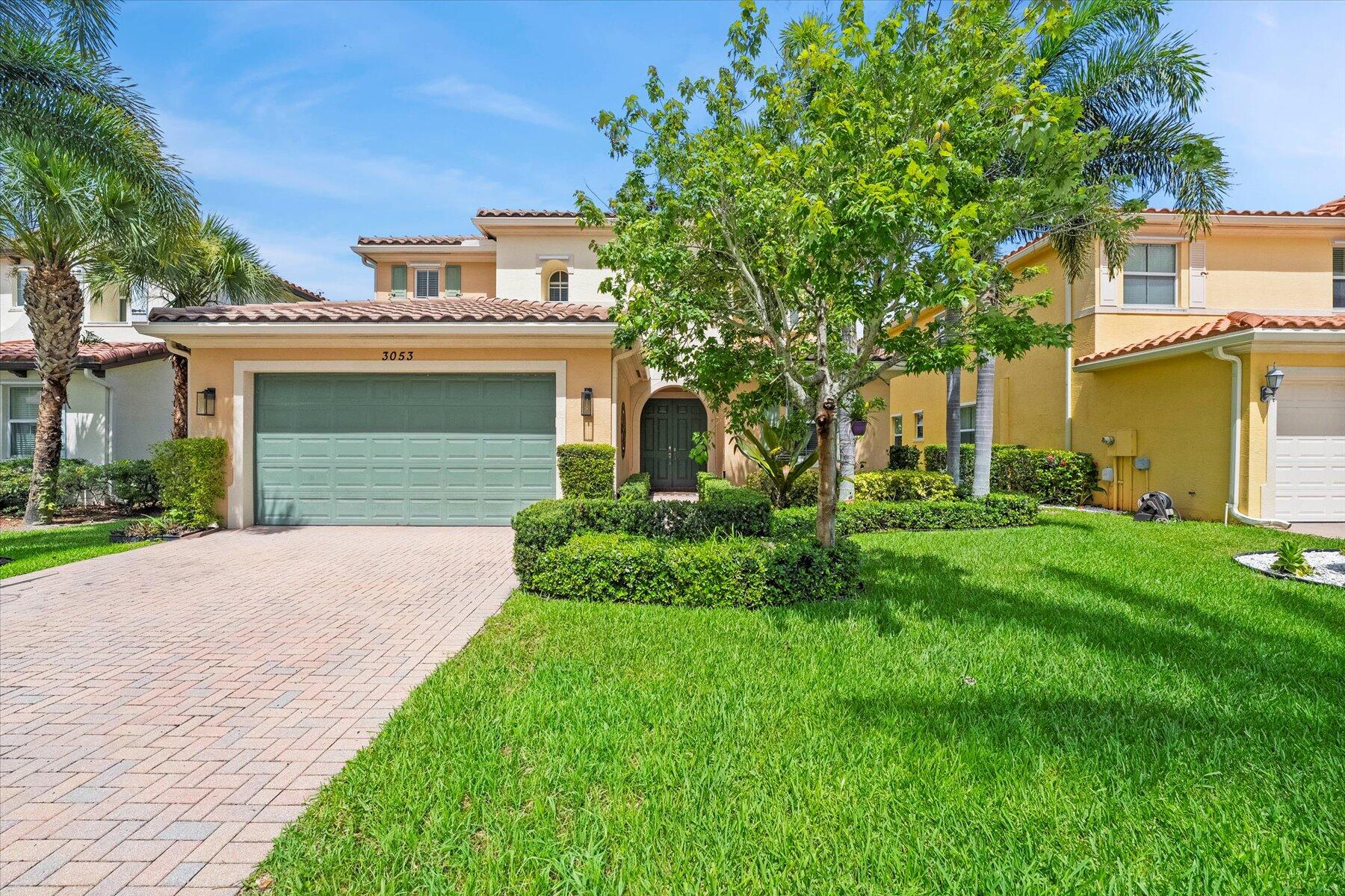 a front view of a house with a garden and garage