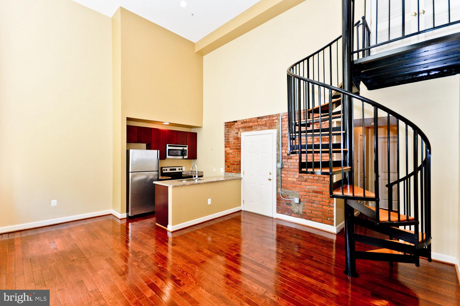 a view of a hallway with wooden floor and staircase