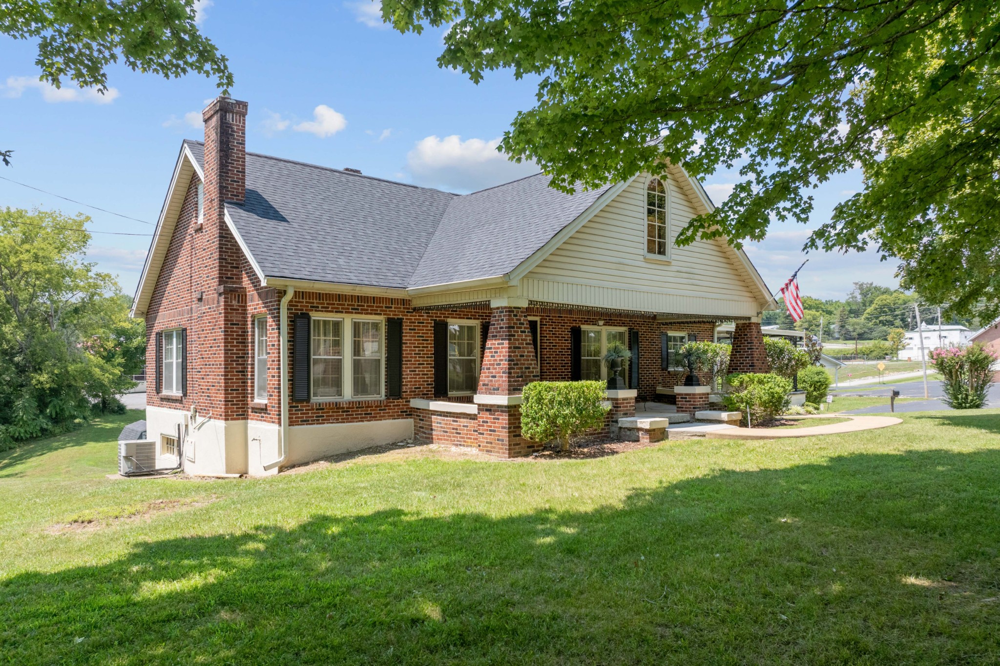 a front view of a house with a yard and trees