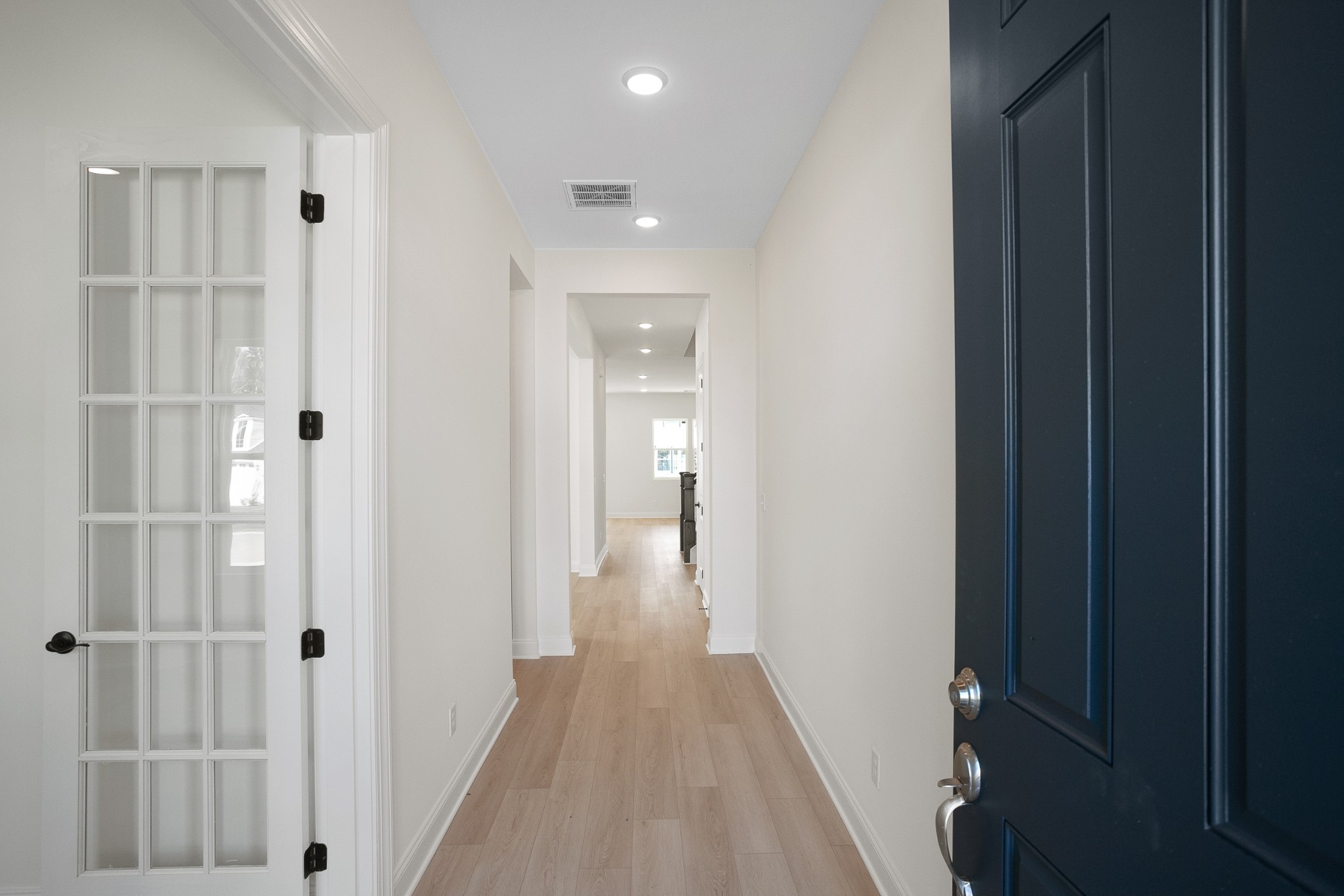 a view of a hallway with wooden floor and closet area