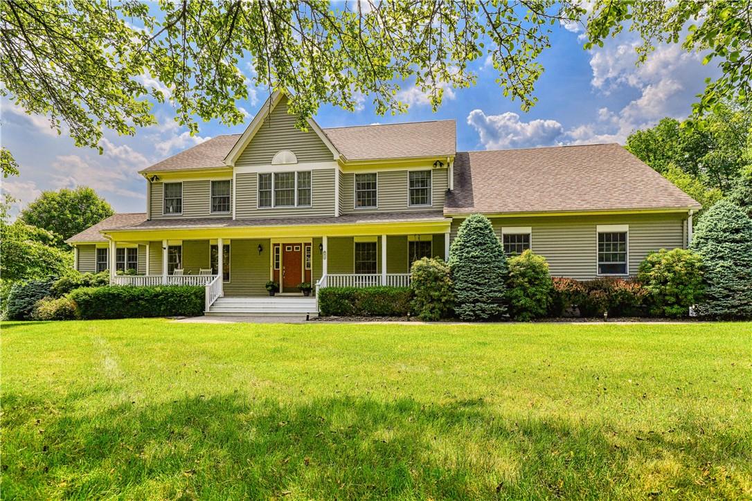 View of the front of a beautiful home with a front lawn and covered porch is very inviting