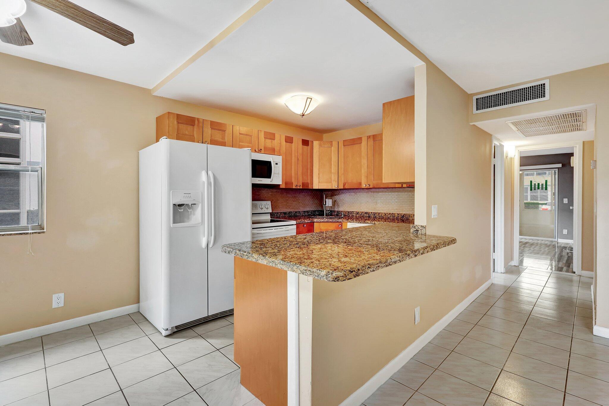 a kitchen with stainless steel appliances granite countertop a refrigerator and a stove