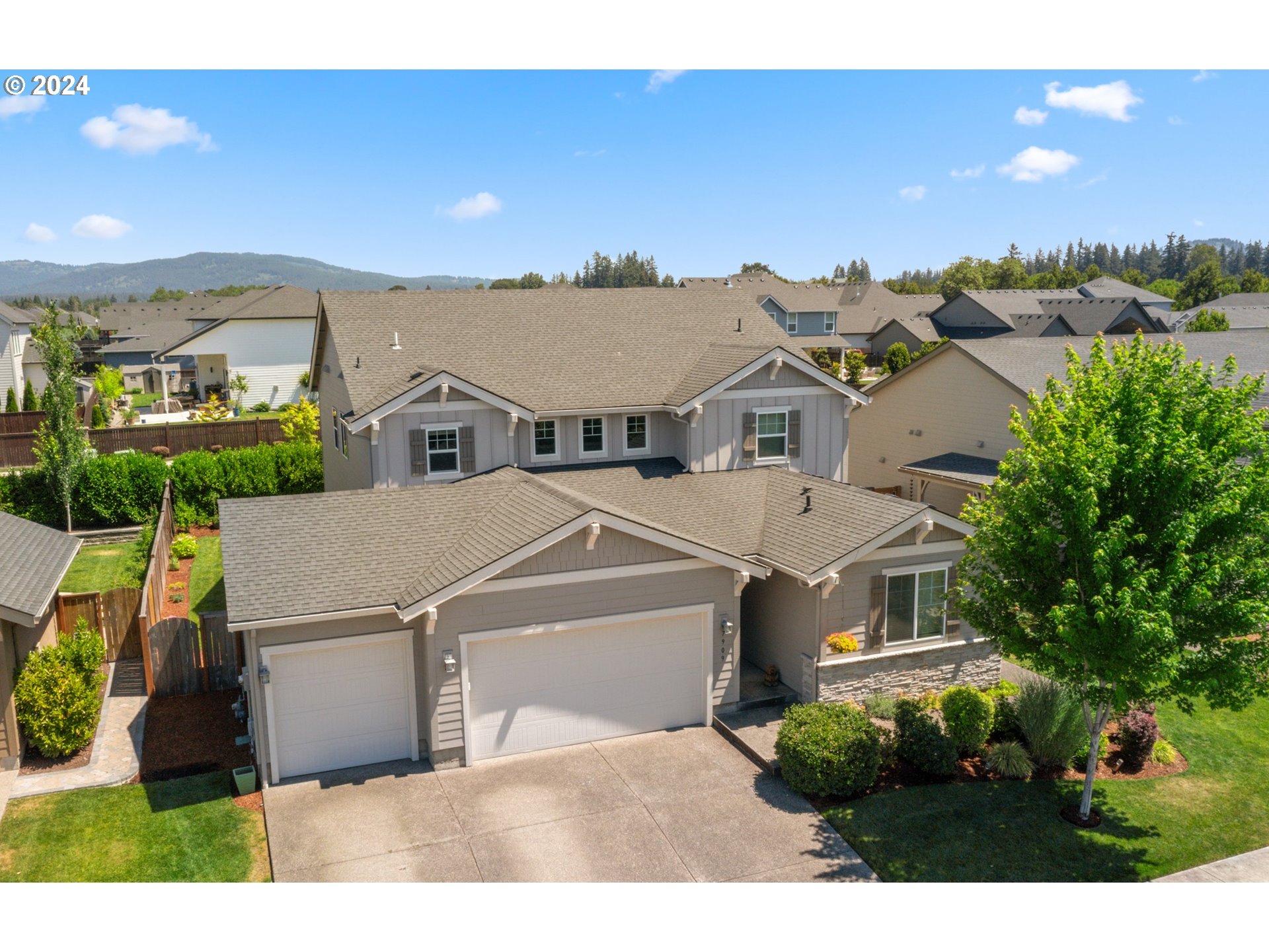 an aerial view of residential houses with outdoor space and trees