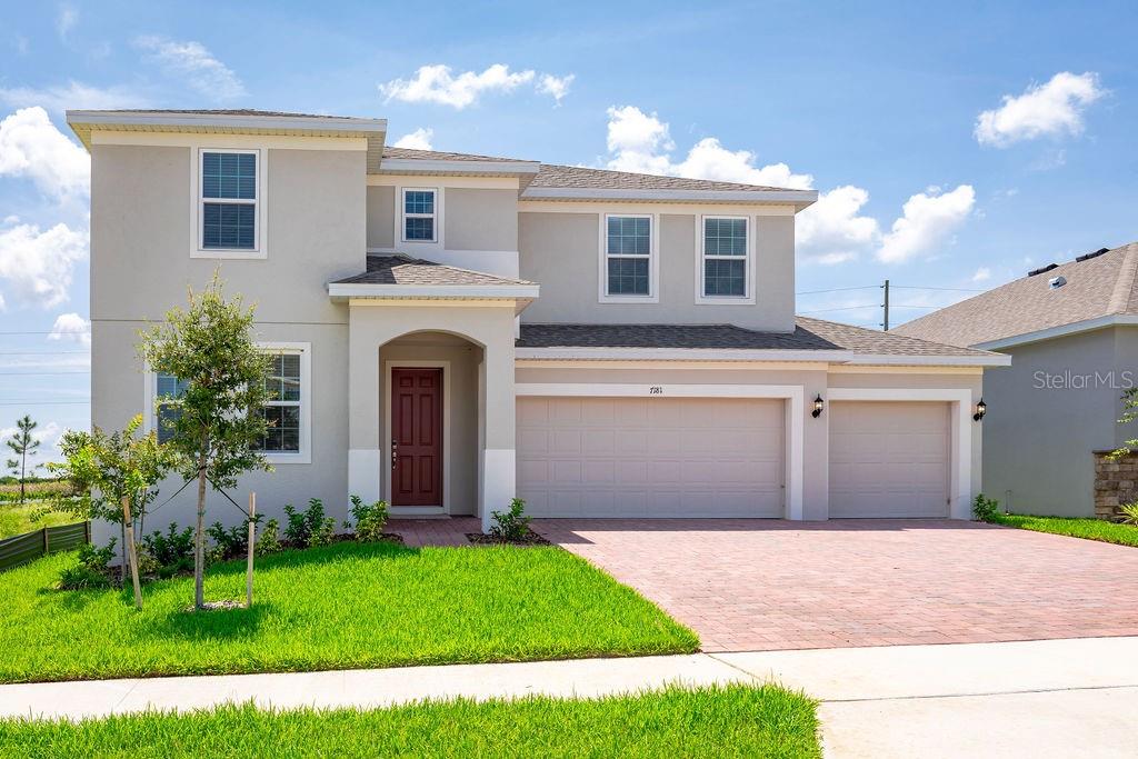 a front view of a house with a garden and yard